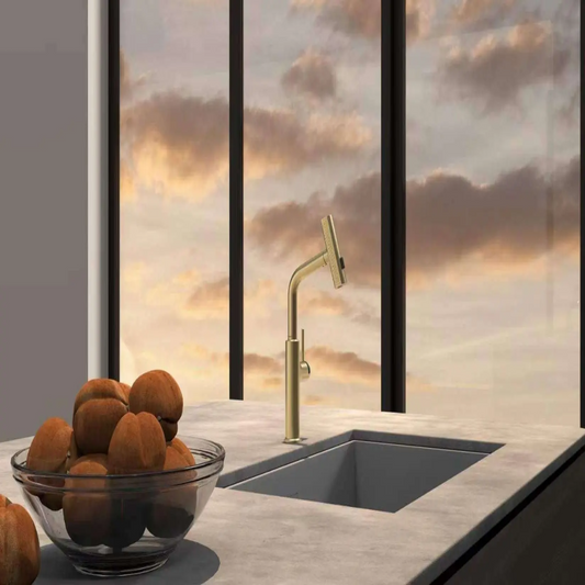 Modern kitchen with a gold faucet and bowl of oranges on a countertop.